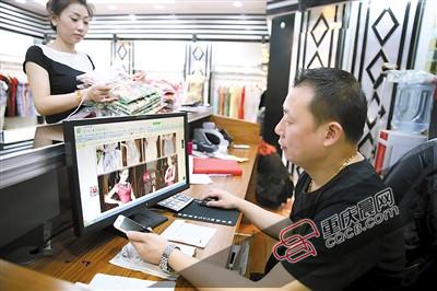 渝中区朝天门批发市场,服装店老板在网上销售旗袍,确定订单后直接打包